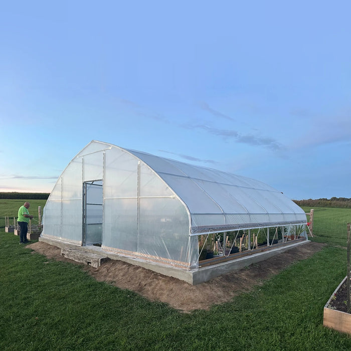 Customer photo: tunnel greenhouse covered with clear poly film, installed on a concrete base in an open field