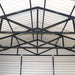 Interior view highlighting black truss system inside metal garage shed.