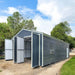 Angled view of metal garage shed showing side window, doors open