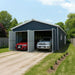 Blue metal garage shed installed outdoors with open double doors and vehicles