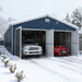Snow-covered driveway with blue metal garage shed open, two cars inside