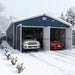 Snowy outdoor scene with open doors, two cars inside metal garage shed